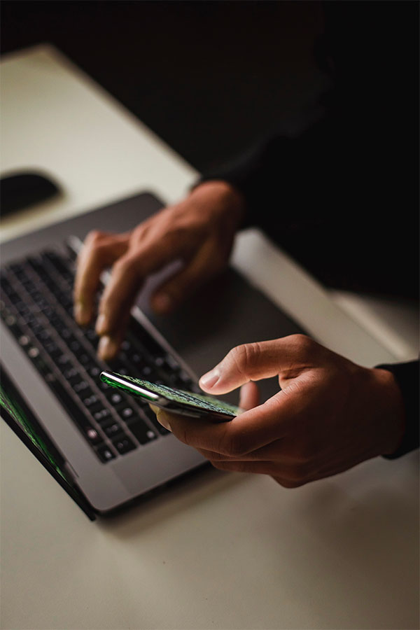 Personne travaillant sur un site internet avec son téléphone et son ordinateur